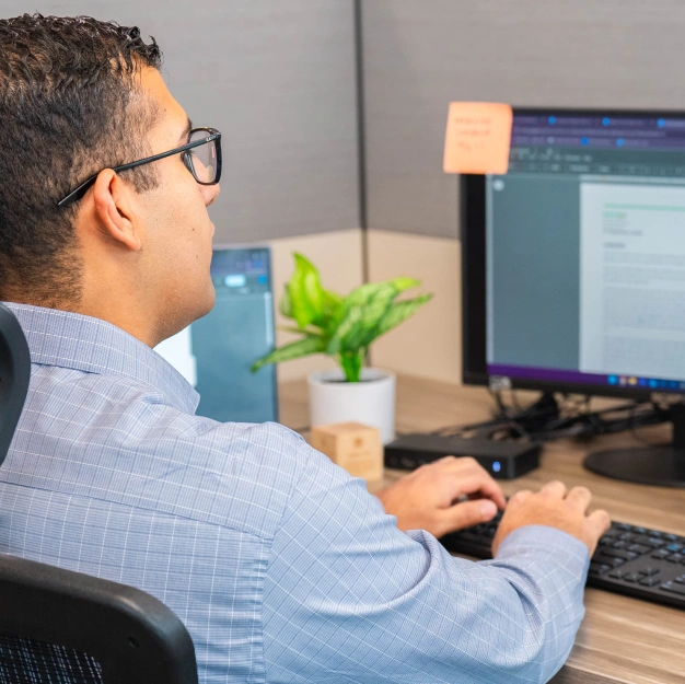 man working at a desk helping a DentalQore customer